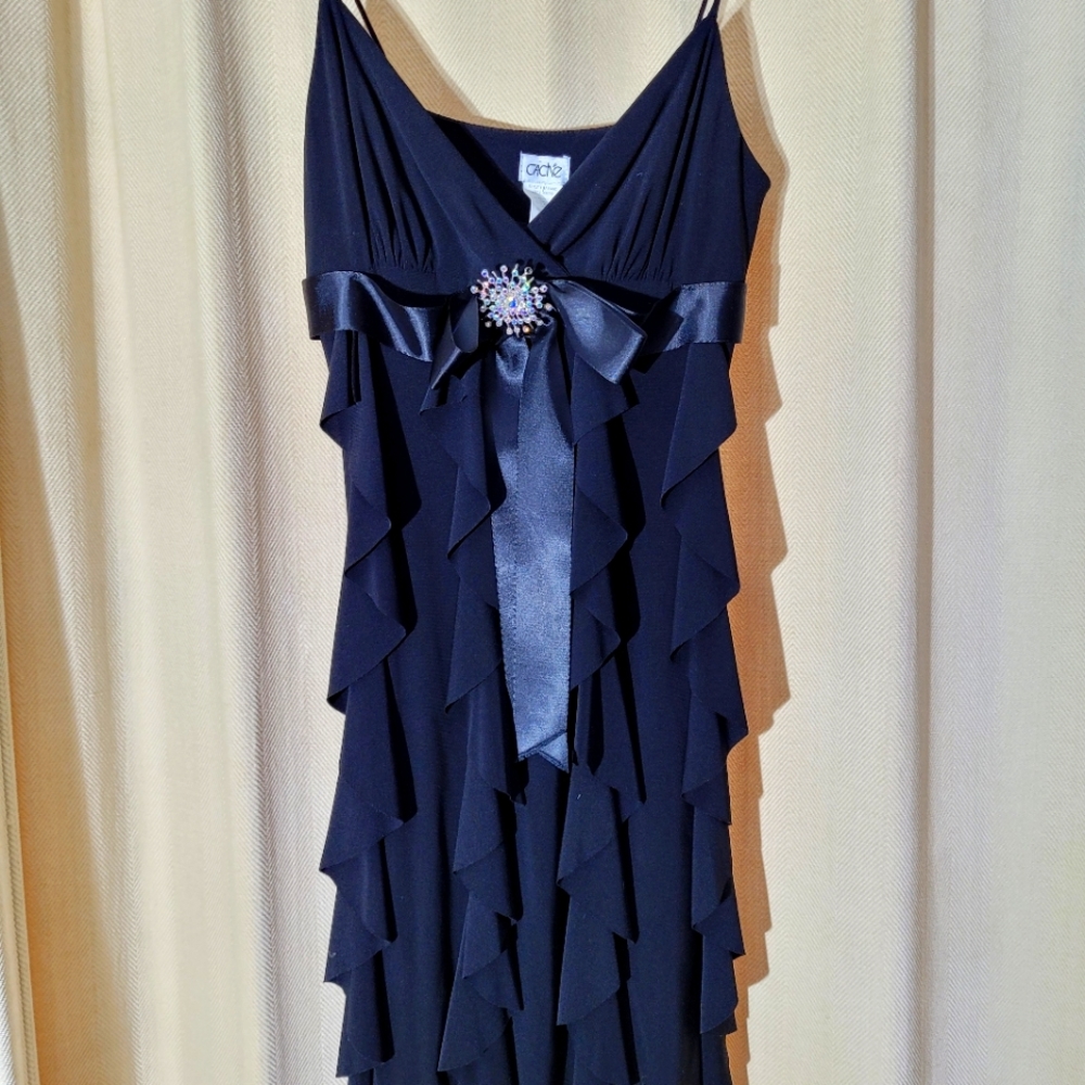Cache black dress with rhinstone broach bow.